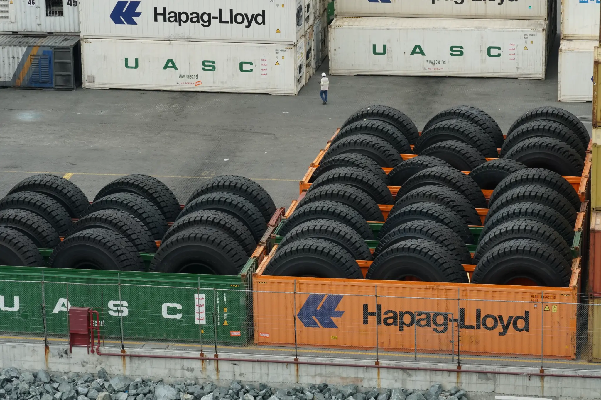 Pneumatiques chargés près de conteneurs maritimes illustrant la logistique internationale